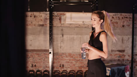 Slow-Motion-Of-Young-Sporty-Woman-With-Water-Bottle-At-Fitness-Club