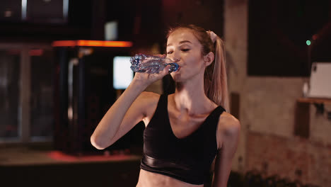 Young-Female-Athlete-Drinking-Water-From-Bottle-After-Workout-Session-At-Health-Club-3
