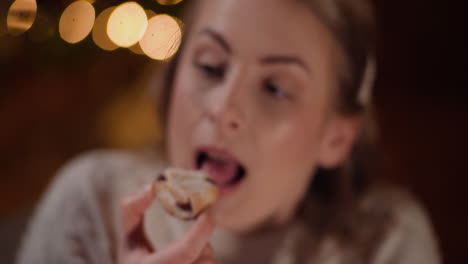Young-Woman-Eating-Sweet-Cake-During-Christmas