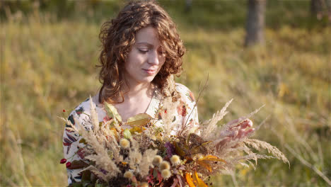 Medium-Shot-Of-Woman-Looking-At-Bouquet-Of-Wild-Flowers-In-Summer