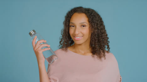 Porträtaufnahme-Einer-Jungen-Erwachsenen-Frau,-Die-Mit-Wasserflasche-Lächelt