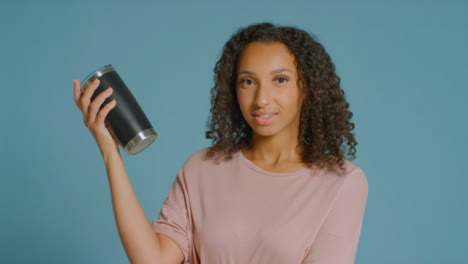 Portrait-Shot-of-Young-Adult-Woman-Holding-Up-Flask