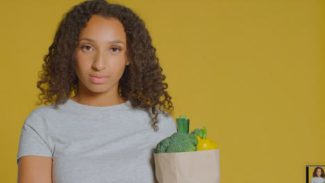 Portrait-Shot-of-Young-Adult-Woman-with-Brown-Paper-Bag-of-Vegetables-with-Copy-Space