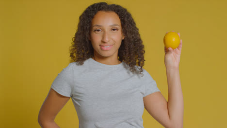 Portrait-Shot-of-Young-Adult-Woman-Holding-Orange