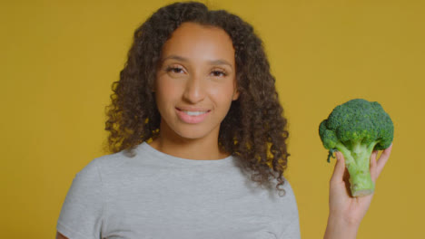 Portrait-Shot-of-Young-Adult-Woman-Holding-Broccoli