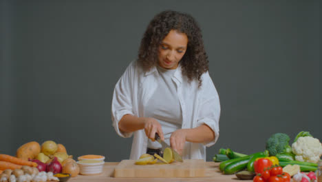 Wide-Shot-of-Young-Adult-Woman-Slicing-Potato-and-Carrot