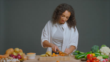 Wide-Shot-of-Young-Adult-Woman-Slicing-Carrot-and-Spring-Onion