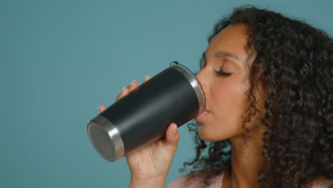 Close-Up-Shot-of-Young-Adult-Woman-Drinking-from-Flask-01
