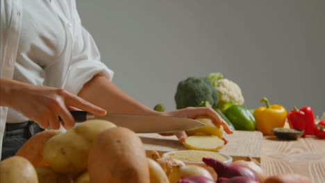 Tracking-Shot-of-Young-Adult-Woman-Slicing-Potato-and-Carrot