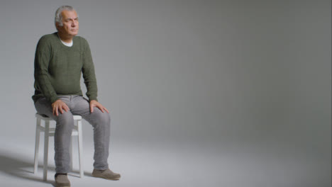 Weitwinkelaufnahme-Eines-älteren-Mannes,-Der-Auf-Einem-Stuhl-Sitzt