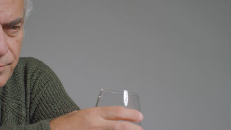Close-Up-Shot-of-Senior-Man-Drinking-Alcohol-with-Copy-Space