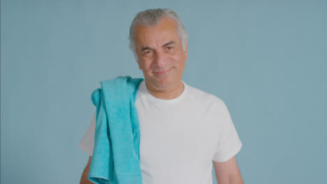 Porträtaufnahme-Eines-älteren-Mannes,-Der-Sich-Ein-Handtuch-über-Die-Schulter-Wirft