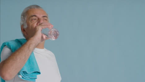Portrait-Shot-of-Senior-Man-Drinking-from-Plastic-Water-Bottle-with-Copy-Space