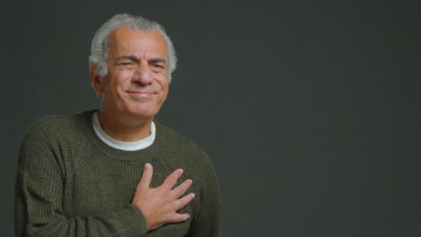 Mittlere-Aufnahme-Eines-älteren-Mannes,-Der-Die-Hand-Vor-Schmerzen-Auf-Die-Brust-Legt