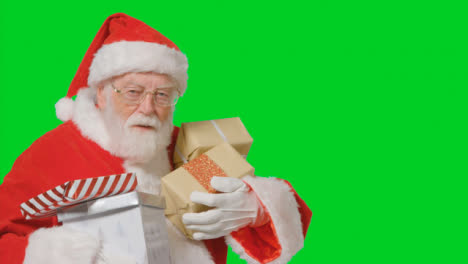 Porträtaufnahme-Von-Santa,-Die-In-Und-Aus-Dem-Rahmen-Geht-Und-Geschenke-Mit-Grünem-Bildschirm-Hält