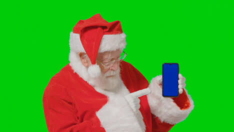Retrato-De-Santa-Sosteniendo-Un-Teléfono-Móvil-Con-Pantalla-Azul-Delante-De-Una-Pantalla-Verde