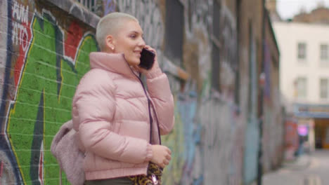 Medium-Shot-of-Young-Woman-Talking-On-Mobile-Phone-On-Urban-Street