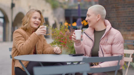 Kamerafahrt-Von-Zwei-Jungen-Frauen,-Die-Am-Tisch-Im-Freien-Sitzen-Und-Kaffee-Trinken