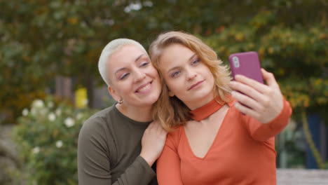 Primer-Plano-De-Dos-Amigos-Tomando-Selfies