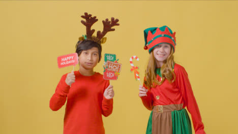 Two-Happy-Children-Holding-Christmas-Signs