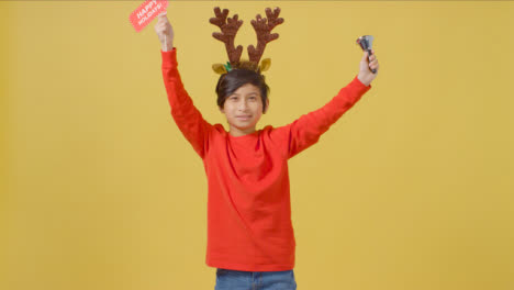 Boy-in-Santa-Hat-Waves-Sign-and-Bell