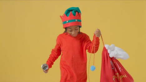 Young-Boy-Walking-Holding-Santa-Sack-and-Bell