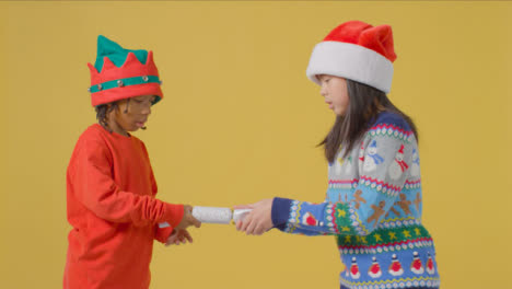 Zwei-Jungs-In-Festlicher-Kleidung-Ziehen-Einen-Weihnachtskracher