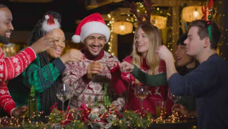 Plano-Deslizante-De-Un-Grupo-De-Amigos-Bebiendo-Tragos-En-El-Bar-En-Navidad