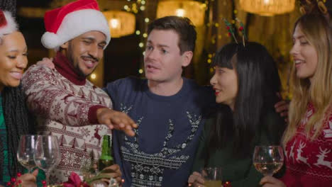 Medium-Shot-of-Drunk-Man-with-His-Friends-During-Christmas-Celebrations-at-a-Bar