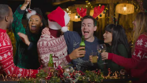 Sliding-Shot-of-Group-of-Friends-Socialising-at-a-Bar-During-Christmas-Celebrations