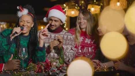 Sliding-Shot-of-a-Group-of-Friends-Singing-Karaoke-During-Christmas-Celebrations