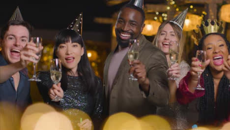 Sliding-Shot-of-Friends-Raising-Glasses-During-New-Year's-Eve-to-Camera