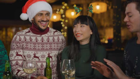 Tracking-Shot-Along-Group-of-Friends-Celebrating-Christmas-at-a-Bar