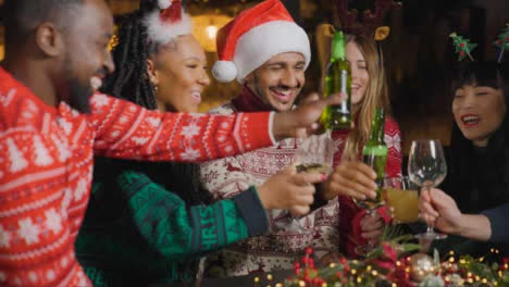 Tiro-De-Seguimiento-De-Un-Grupo-De-Amigos-Celebrando-La-Navidad-En-El-Bar