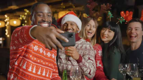 Tracking-Shot-of-Friends-Taking-a-Group-Photo-During-Christmas-Celebrations