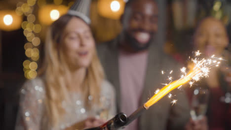 Close-Up-Shot-of-Champagne-Sparkler-as-Friends-Celebrate-New-Years-Eve