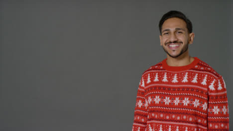 Porträtaufnahme-Eines-Jungen-Mannes-Im-Weihnachtspullover,-Der-Frohe-Weihnachten-Mit-Textfreiraum-Sagt