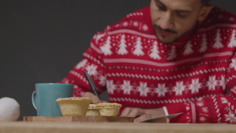 Flachwinkelaufnahme-Eines-Jungen-Mannes-Im-Weihnachtspullover,-Der-Weihnachtskarten-Schreibt