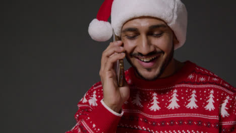 Close-Up-Shot-of-a-Young-Man-Writing-Christmas-Cards-and-Taking-Phone-Call