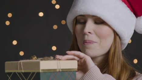 Close-Up-Shot-of-Young-Woman-Smiling-and-Opening-Christmas-Gift