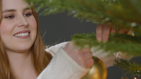 Close-Up-Shot-of-Young-Woman-Decorating-Christmas-Tree