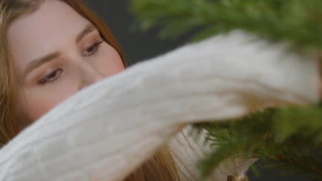 Close-Up-Shot-of-Young-Woman-Decorating-Christmas-Tree