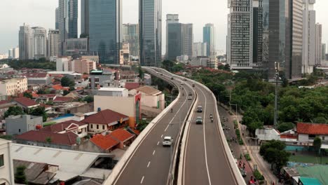 Drone-Shot-Panning-Up-Over-Highway-Revealing-Downtown-Jakarta