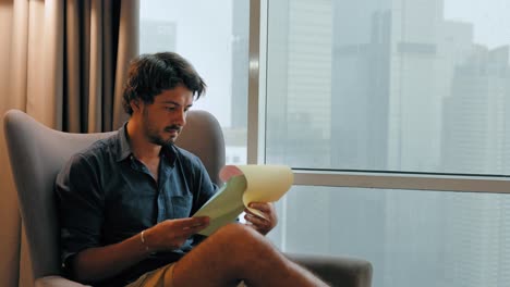 Mid-Shot-of-Man-Reading-Paper-in-Jakarta