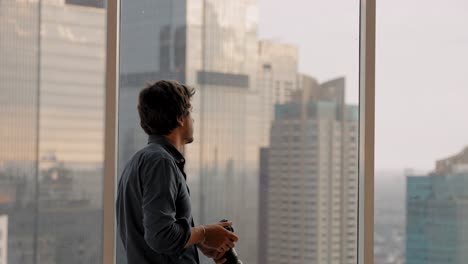 Long-Shot-of-Man-Taking-Photos-in-Window