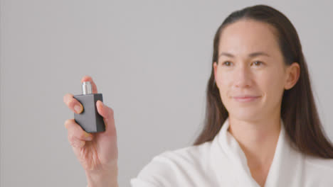 Mid-Shot-of-Woman-Smiling-and-Spraying-Perfume
