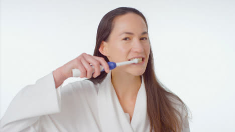 Mid-Shot-of-Young-Woman-Smiling-and-Brushing-her-Teeth