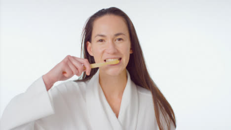 Mid-Shot-of-Young-Woman-Smiling-and-Brushing-Her-Teeth
