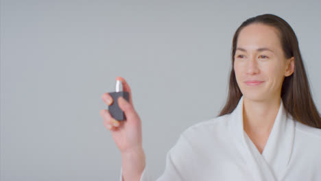 Mid-Shot-of-woman-Smiling-and-Spraying-On-Perfume-with-Copy-Space