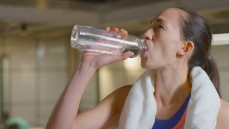 Mid-Shot-of-Woman-Drinking-Water-and-Wiping-Sweat-with-Copy-Space